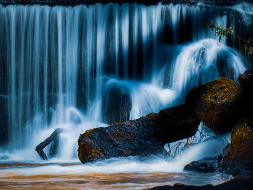 Free A beautiful waterfall cascading over rocks, creating a serene and tranquil scene. Stock Photo