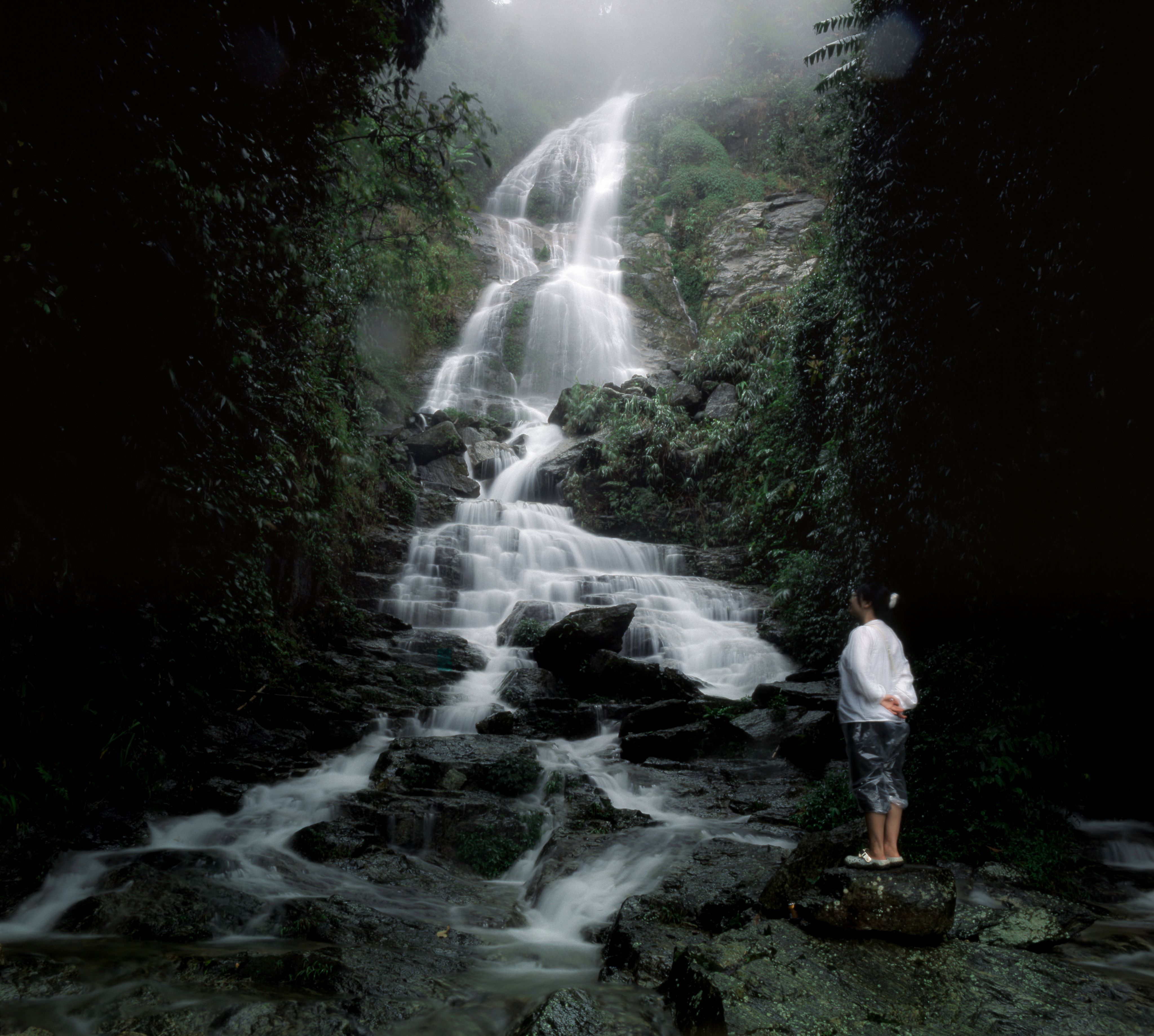 A man standing in front of a waterfall · Free Stock Photo