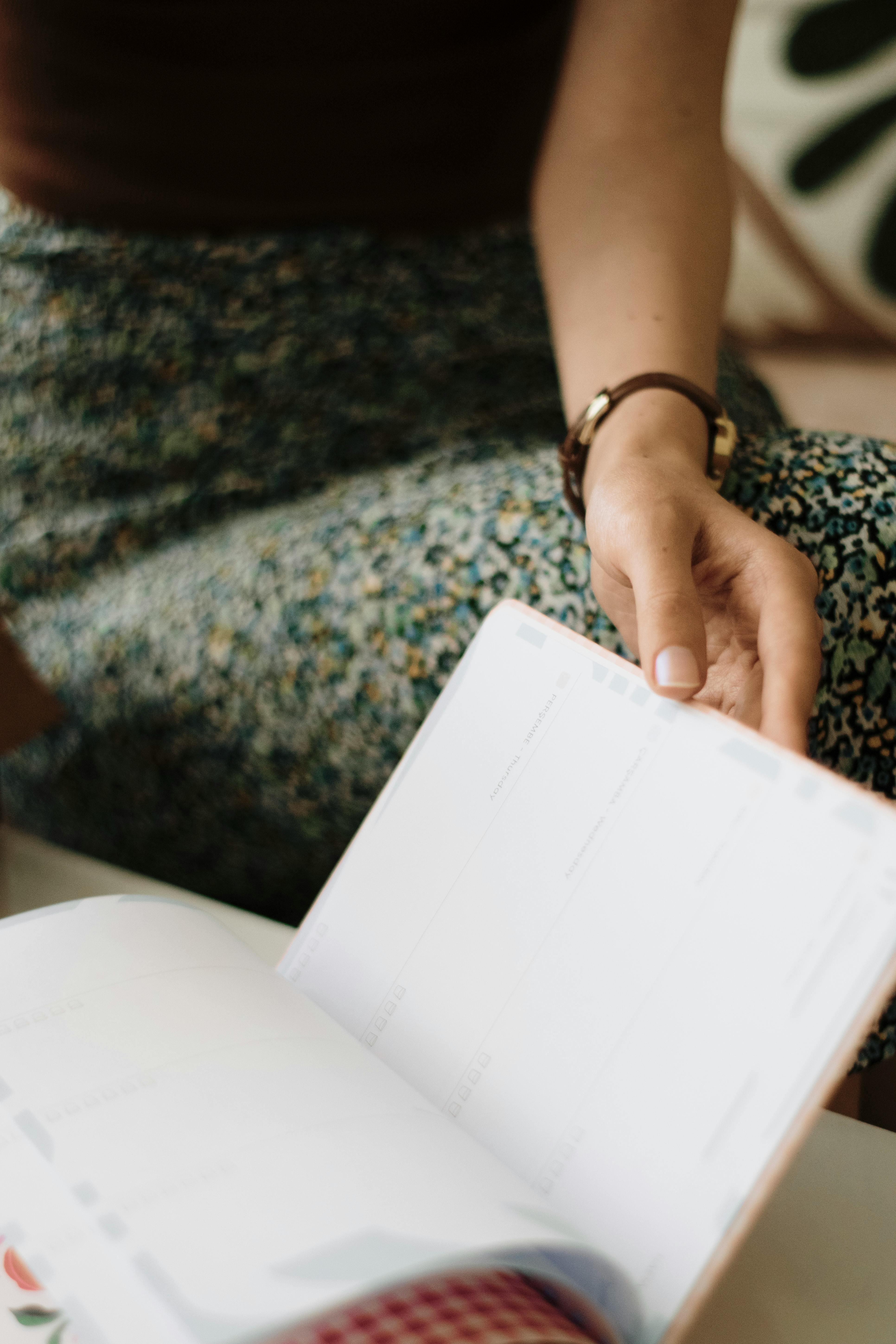A woman is holding a book with a calendar on it