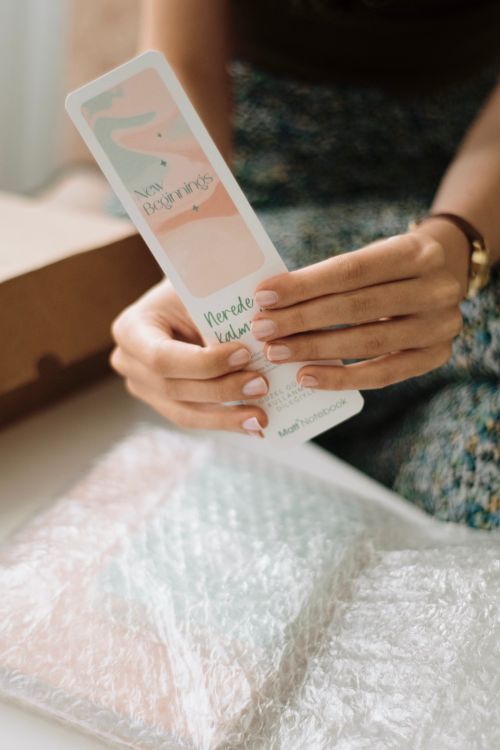 Free A woman carefully unboxes a luxury item, showcasing attention to detail. Stock Photo