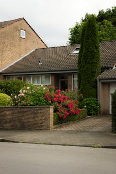 Cozy suburban brick house with vibrant garden and driveway.