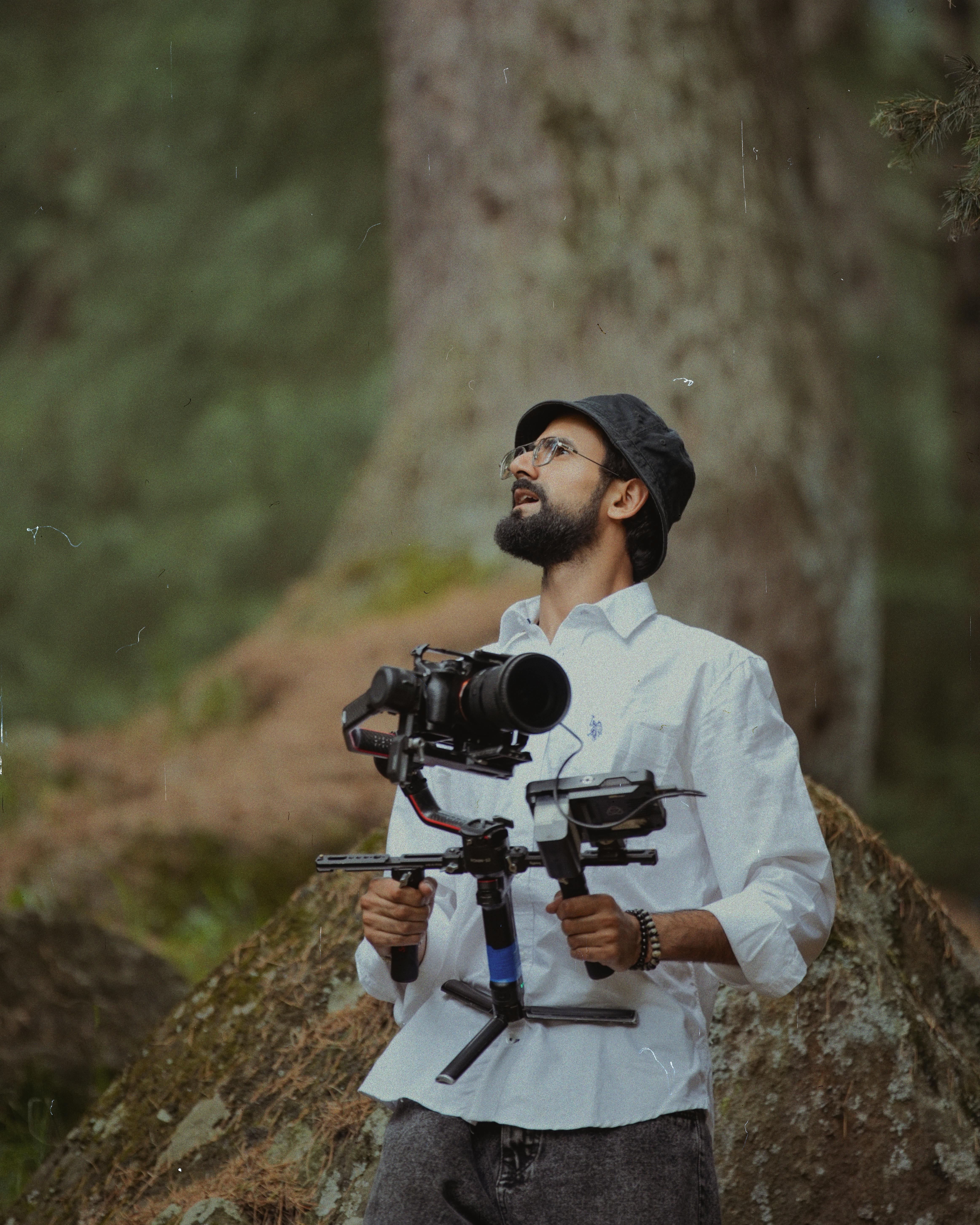 Photographer with camera rig focusing outdoors in a forest scenery