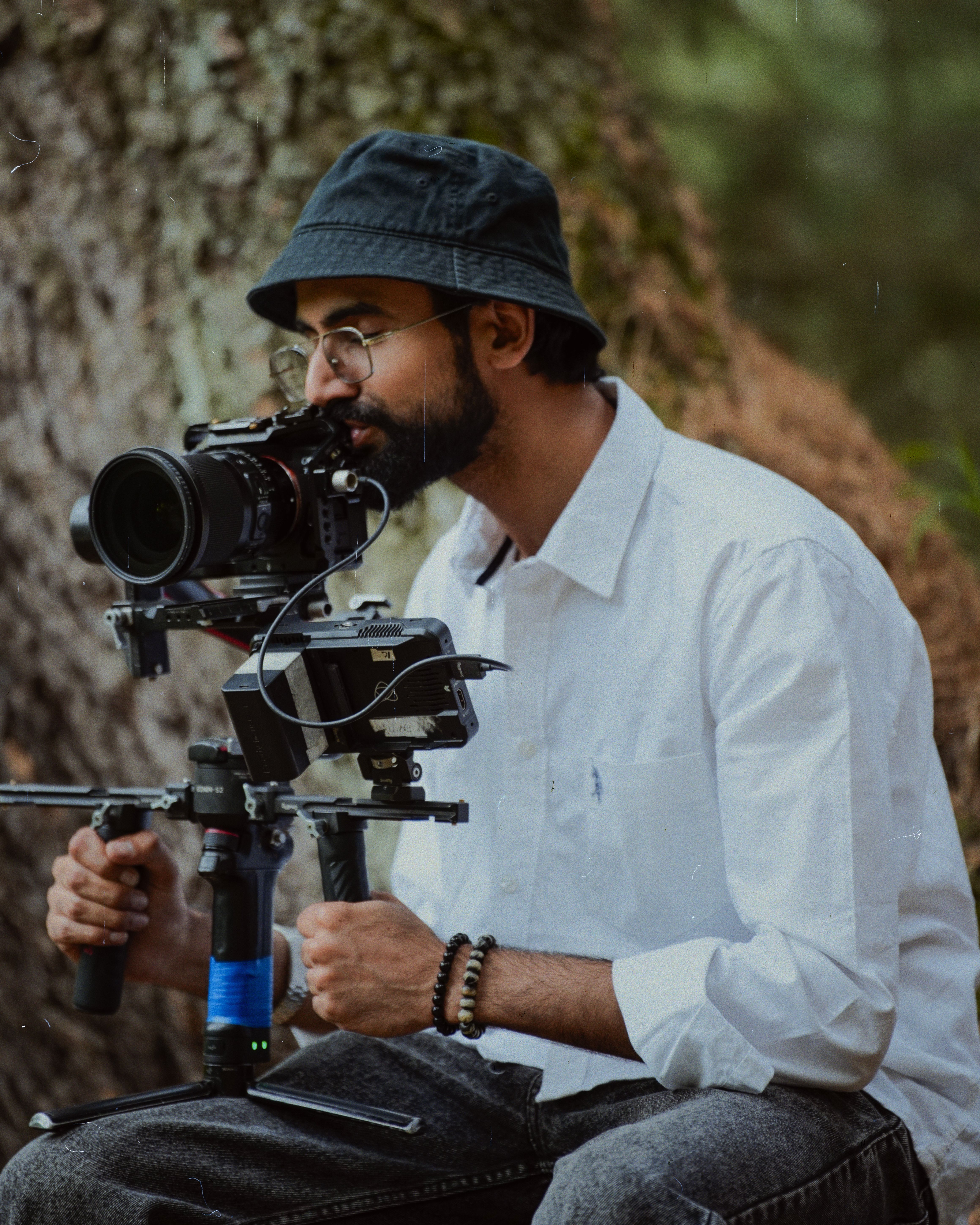 Adult male using professional camera equipment in an outdoor setting.