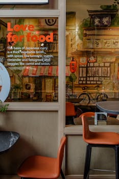 Colorful Japanese themed restaurant interior with seating, bicycle artwork, and a love for food message in Rotterdam.