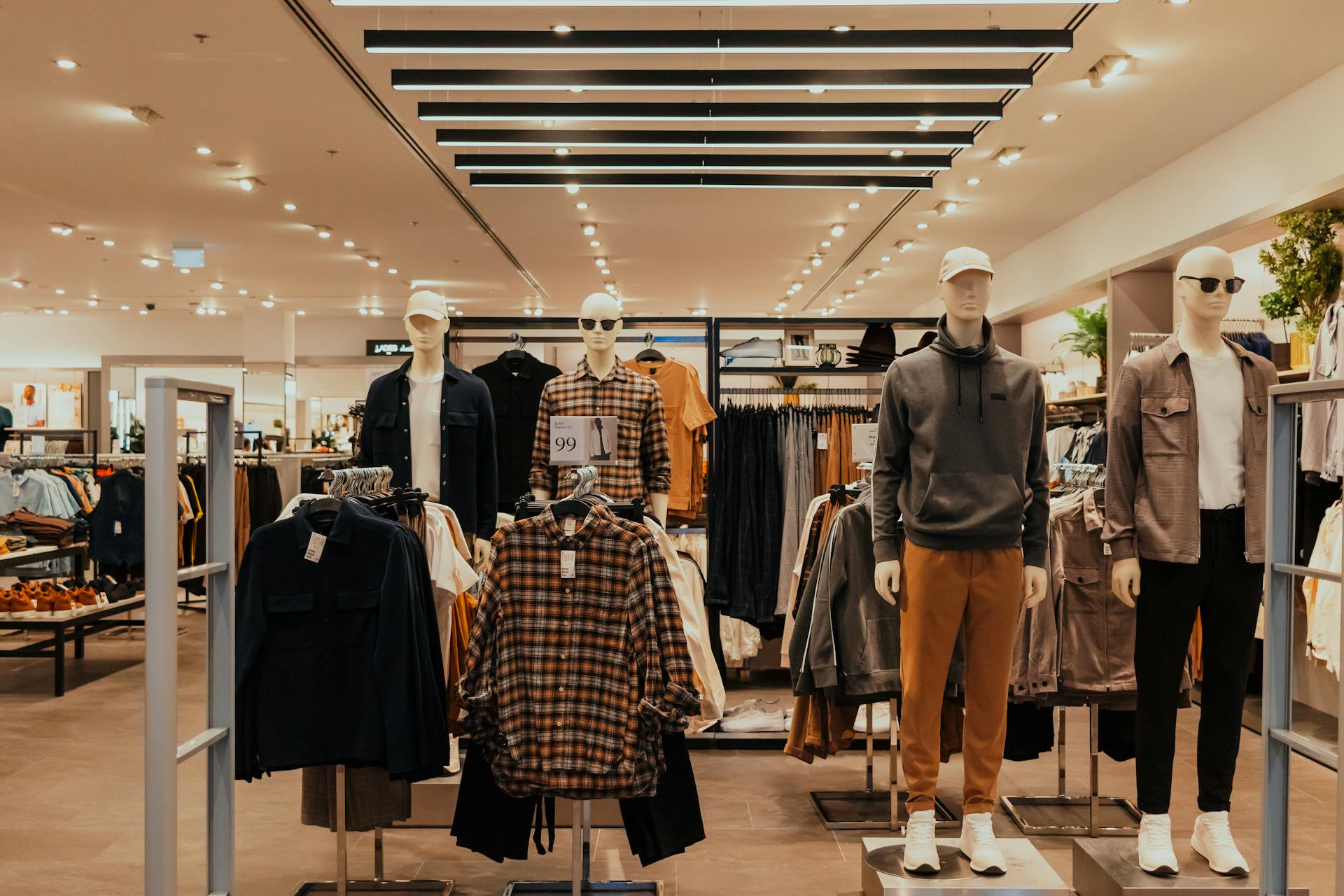 A retail shopping store with a lot of clothing and manikins