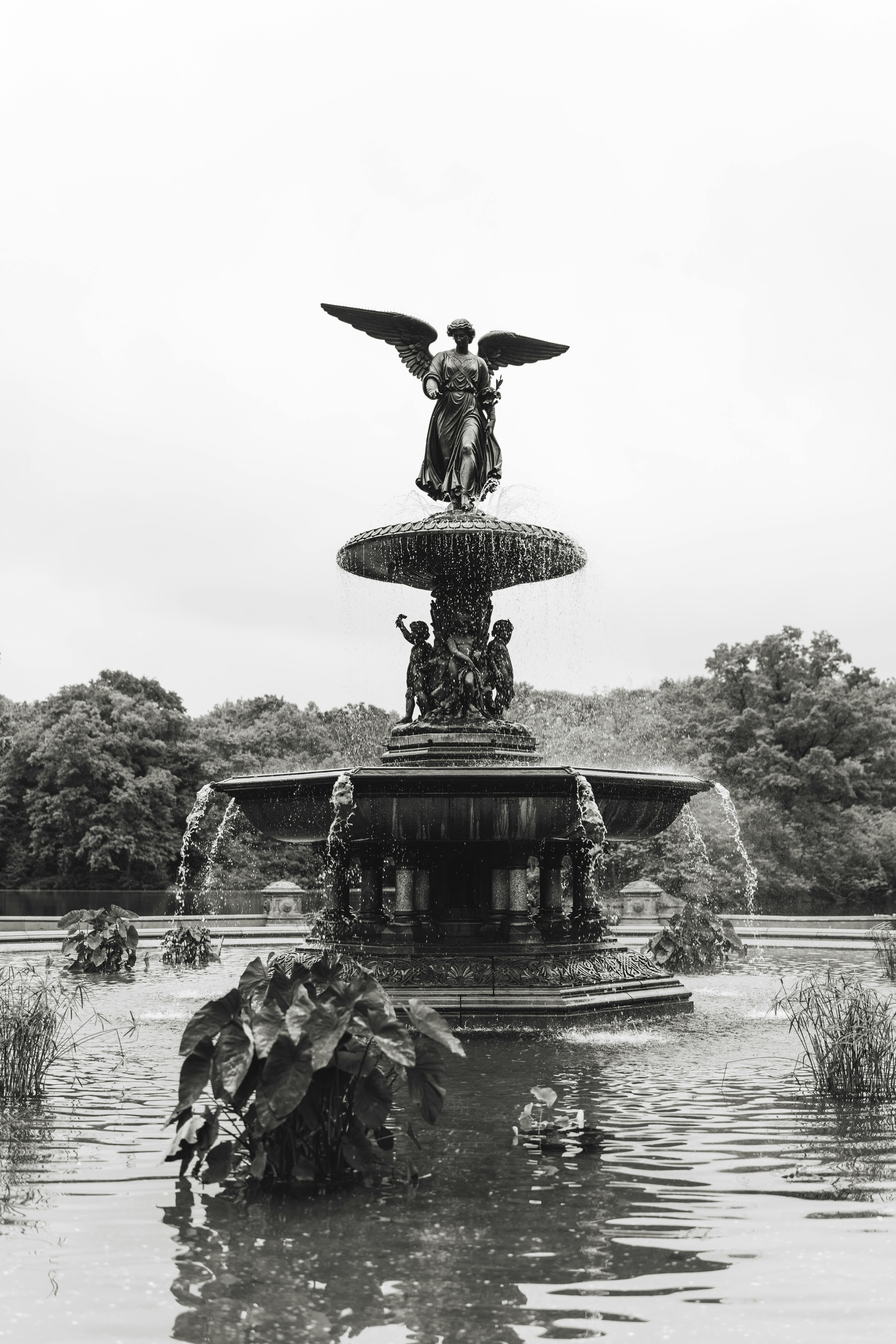 a black and white photo of a fountain with an angel