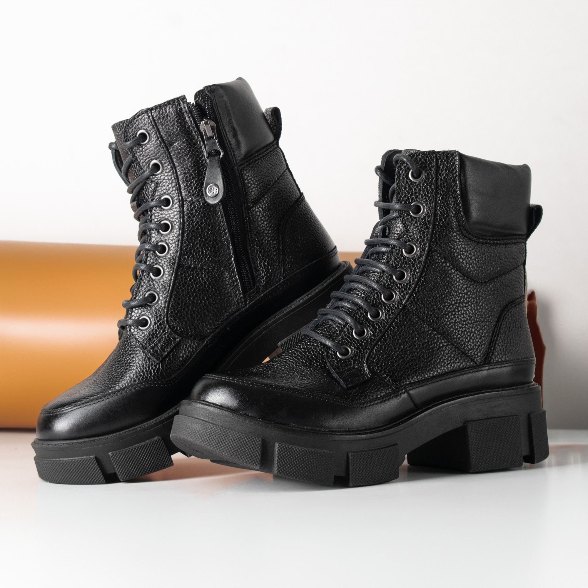 Stylish black leather boots featuring laces and side zippers, perfect for fashion and footwear collections.