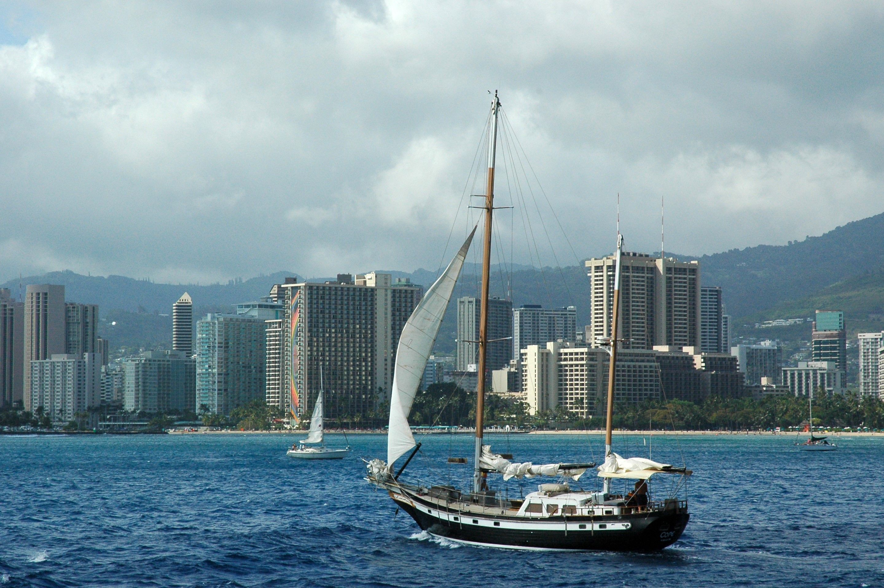 Stunning Exceptional Maui Whale Watch Review: A Luxury Encounter with Hawaii's Giants Review 2026 - A scenic view of a sailboat cruising near the skyline of Honolulu, Hawaii.