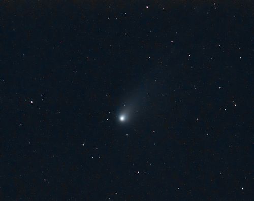 Free A stunning view of a comet against a backdrop of stars in the night sky over Toledo, Spain. Stock Photo