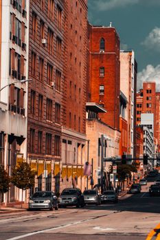 A vibrant city street lined with historic brick buildings under a clear blue sky.