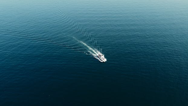 Drone captures a boat in serene turquoise waters near Heybeliada, Istanbul, perfect for travel enthusiasts.