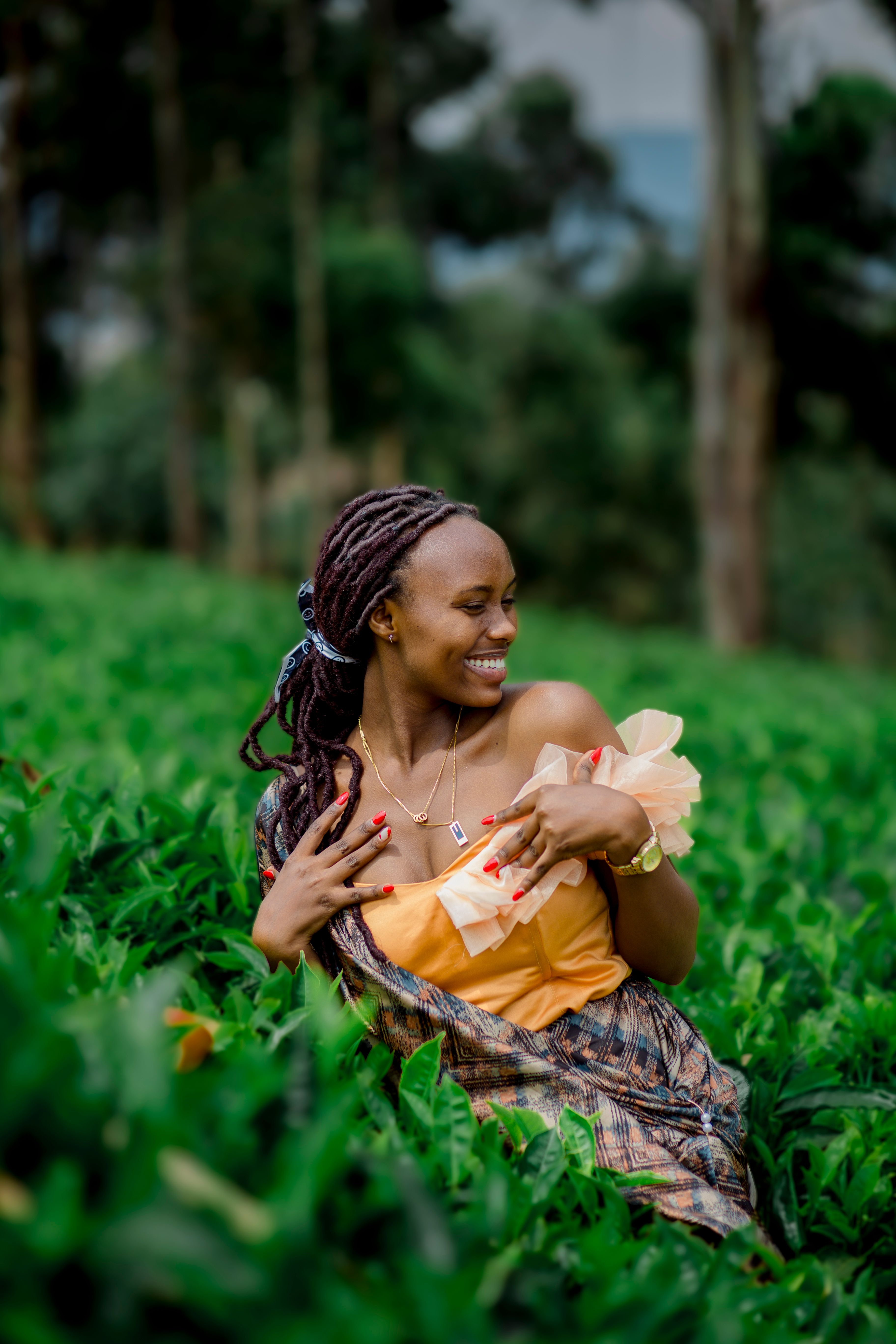 Radiant woman in colorful traditional attire enjoying the outdoors.