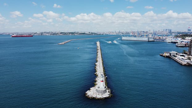 Aerial shot of Kadıköy pier and lighthouse with the bustling Istanbul skyline in the background.