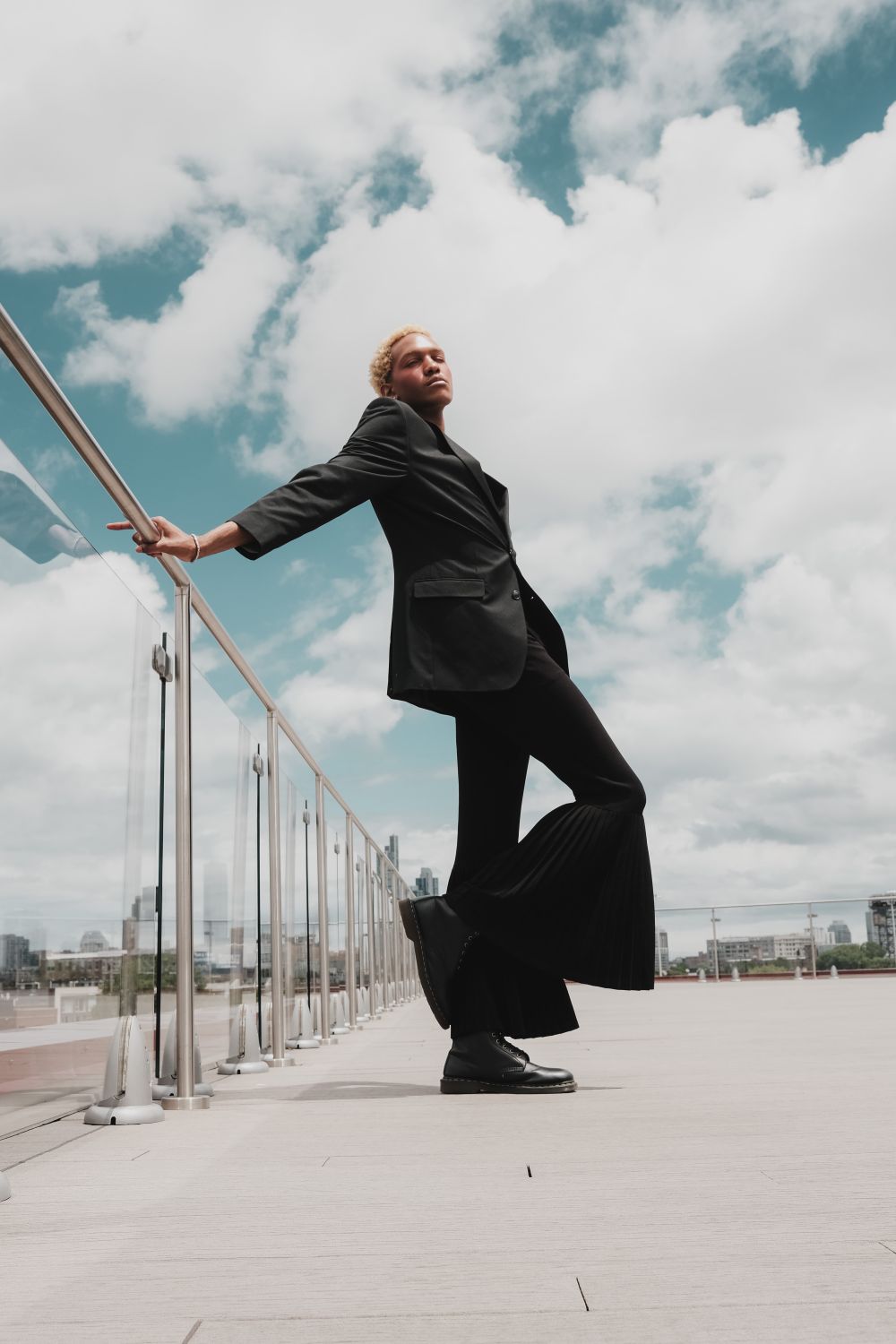 Man in Black Suit Leaning on Railing · Free Stock Photo