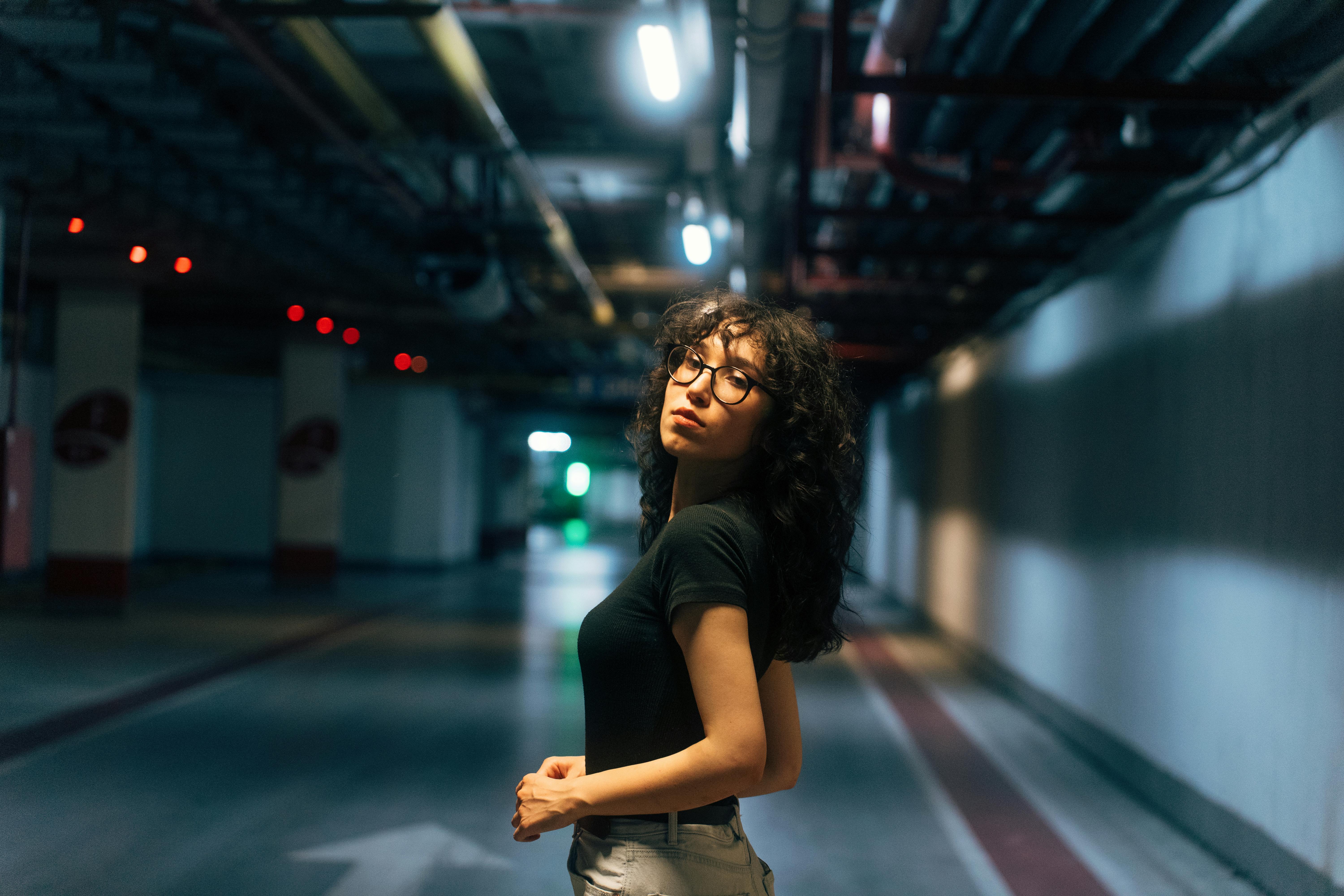 a woman standing in an empty parking garage