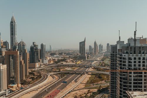 Free Discover Dubai's urban skyline with towering skyscrapers and highways in this aerial photo. Stock Photo