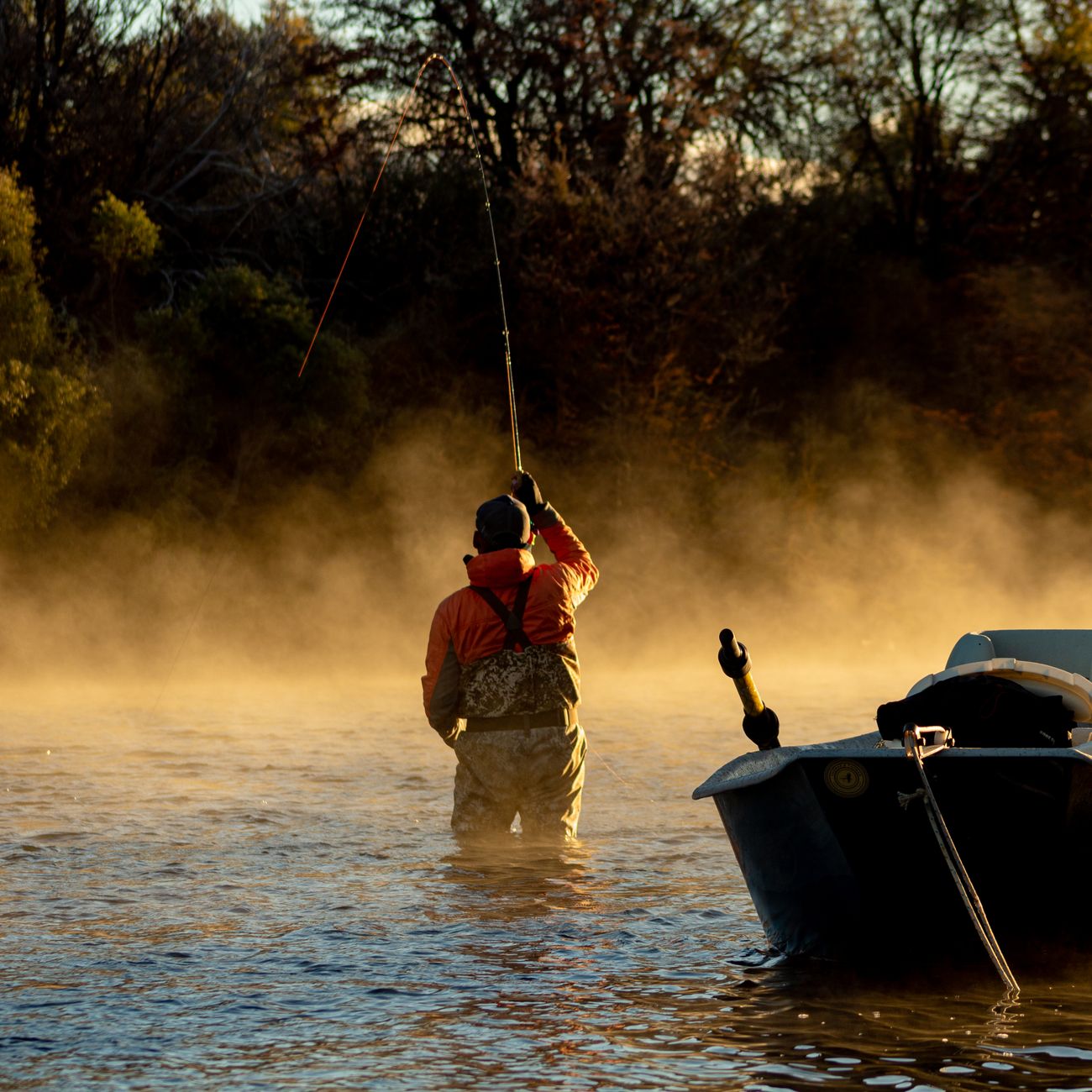 A fisherman in waders casts his line at dawn in a misty river in Neuquén, Argentina.