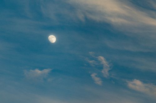 Free Tranquil sky featuring the moon and delicate clouds, captured during sunset. Stock Photo