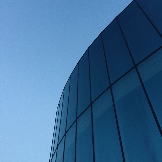 Low-angle view of a contemporary glass building exterior in Pamplona, Spain.