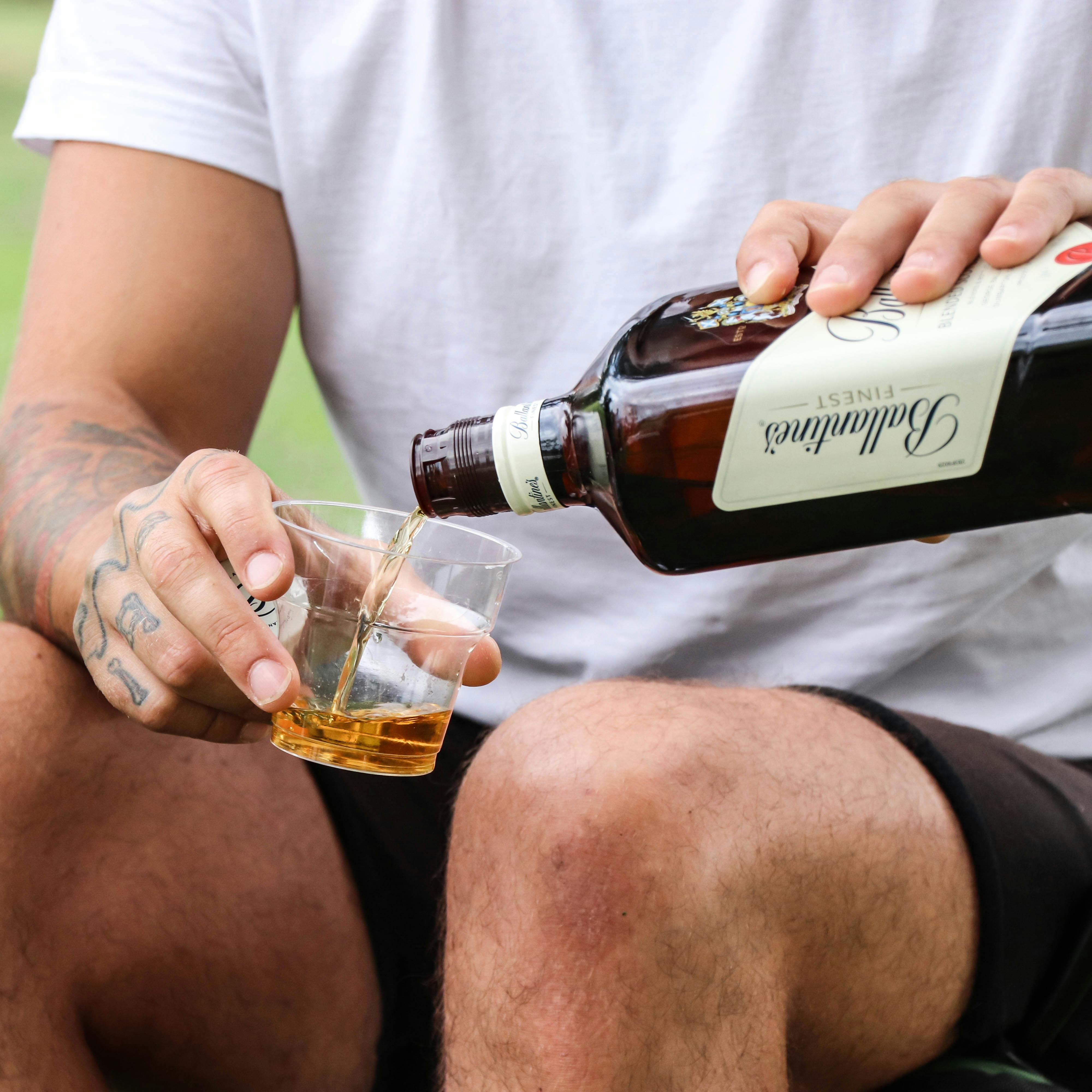 a man is holding a bottle of whiskey