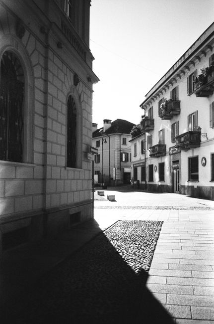 Monochrome urban scene showcasing dramatic shadows and classic architecture.