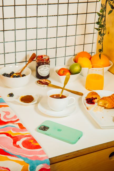 A cozy breakfast scene featuring croissants, fruit, jam, and more, perfect for a fresh start to the day.