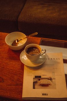 Warm morning scene with a coffee cup, journal, and breakfast setting, evoking a relaxed atmosphere.
