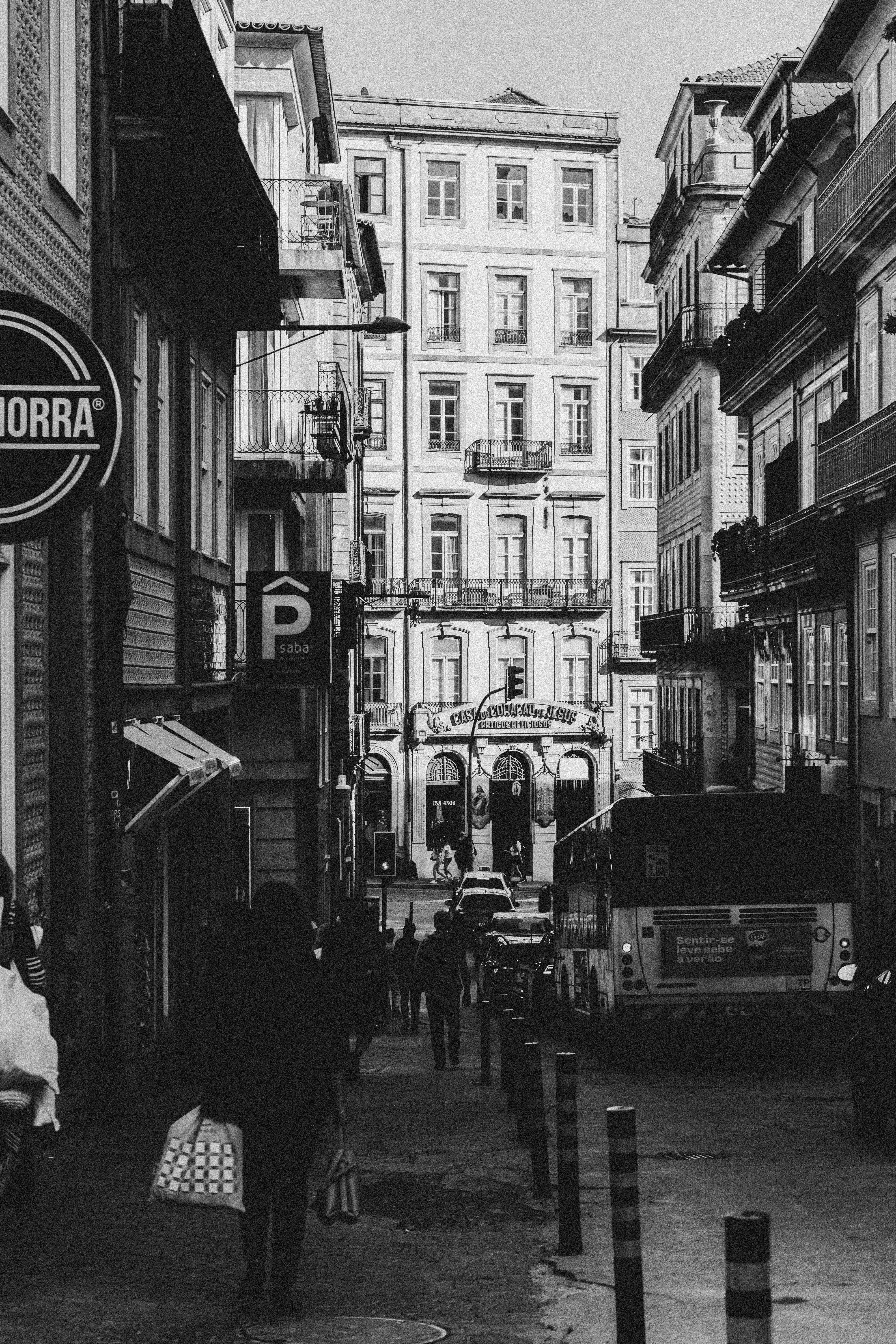 a black and white photo of a street with people walking