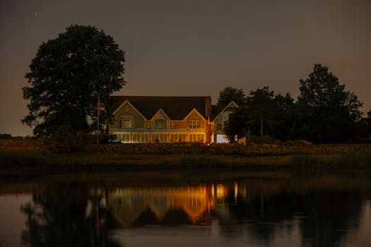 A tranquil lakeside house reflecting on water during twilight in Stamford, CT.