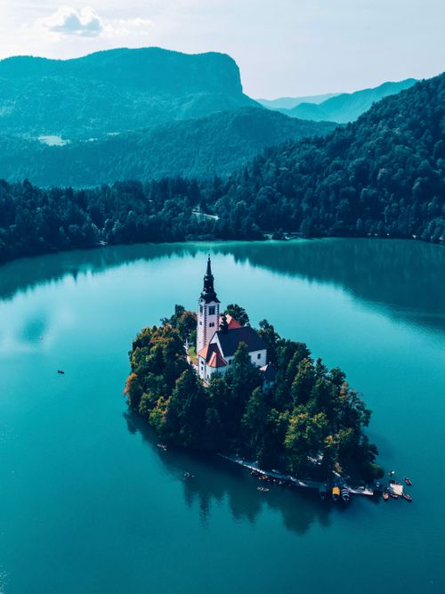Free Stunning aerial shot of Bled Island with its iconic church surrounded by turquoise lake. Stock Photo