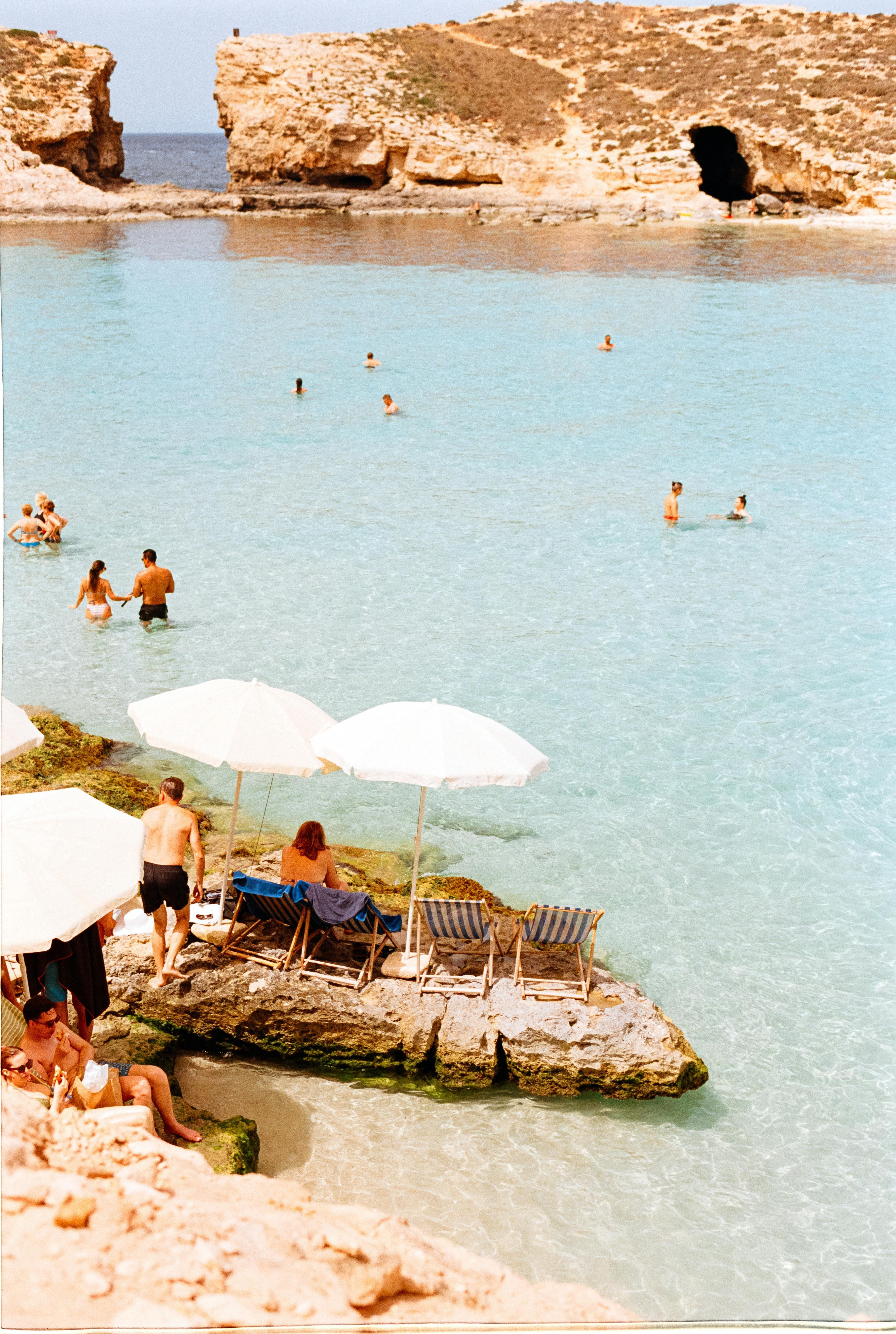 Tourists enjoy leisure time at the stunning Blue Lagoon in Malta.