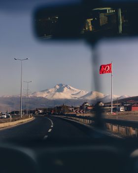 Breathtaking view of Mount Erciyes from a highway in Kayseri, Türkiye, near sunset.