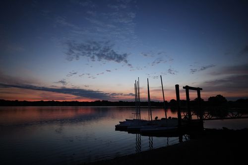 Free Reflective twilight view of Silhouetted Pier and Lake in Stamford, CT, creating a calming landscape. Stock Photo