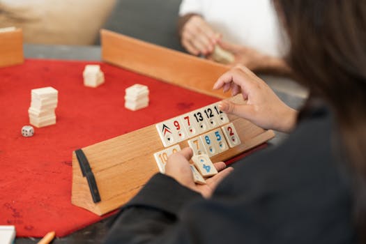 People engaged in a game of Rummikub, showcasing strategy and leisure indoors.