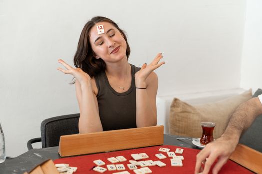 Woman enjoying a light-hearted board game indoors, expressing fun and relaxation in Yalova, Türkiye.