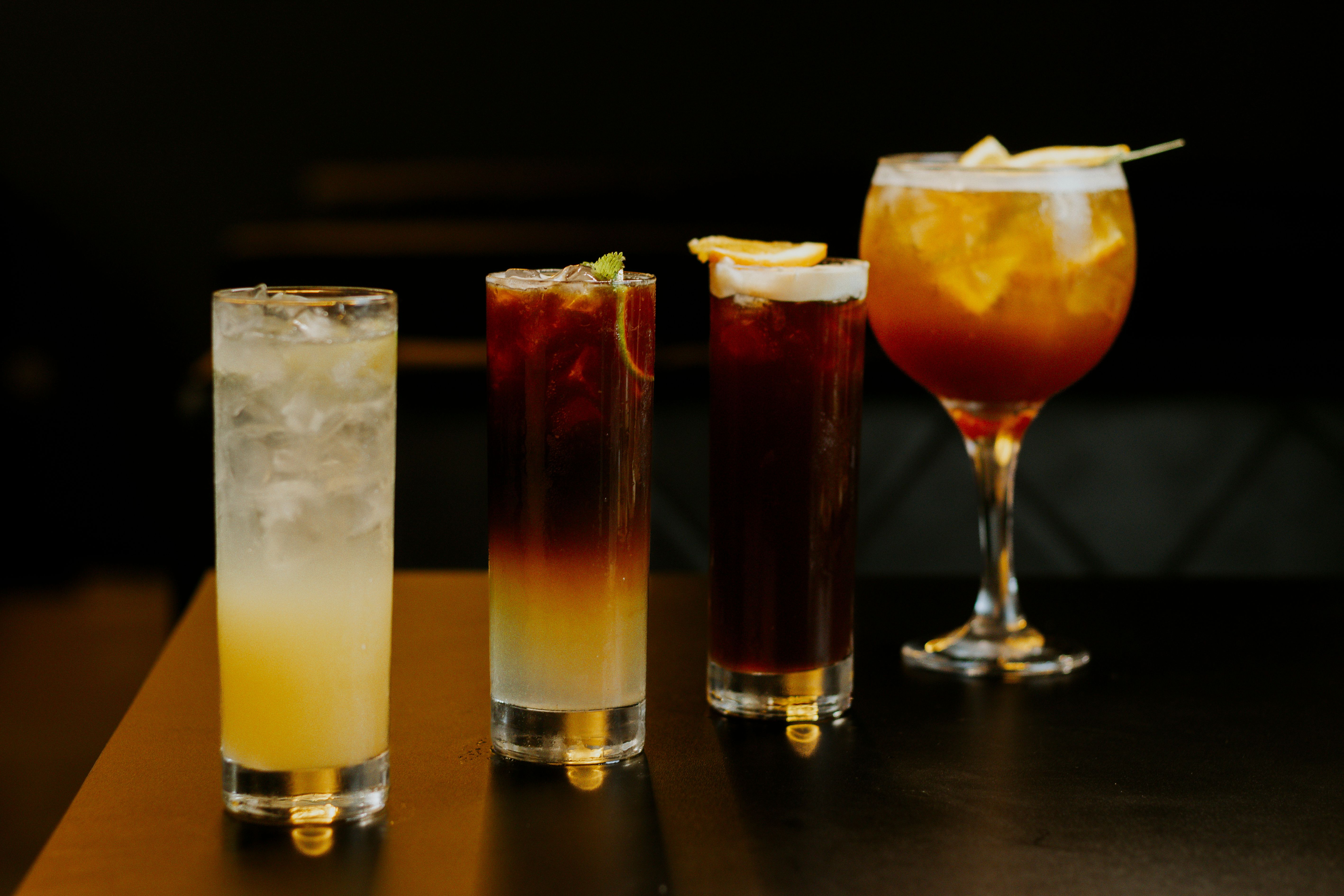 A stylish presentation of four chilled cocktails in various glasses, perfect for nightlife and social gatherings.