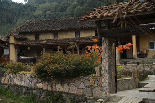 Free Explore a rustic traditional house in Ha Giang, Vietnam, surrounded by lush gardens and vibrant flowers. Stock Photo