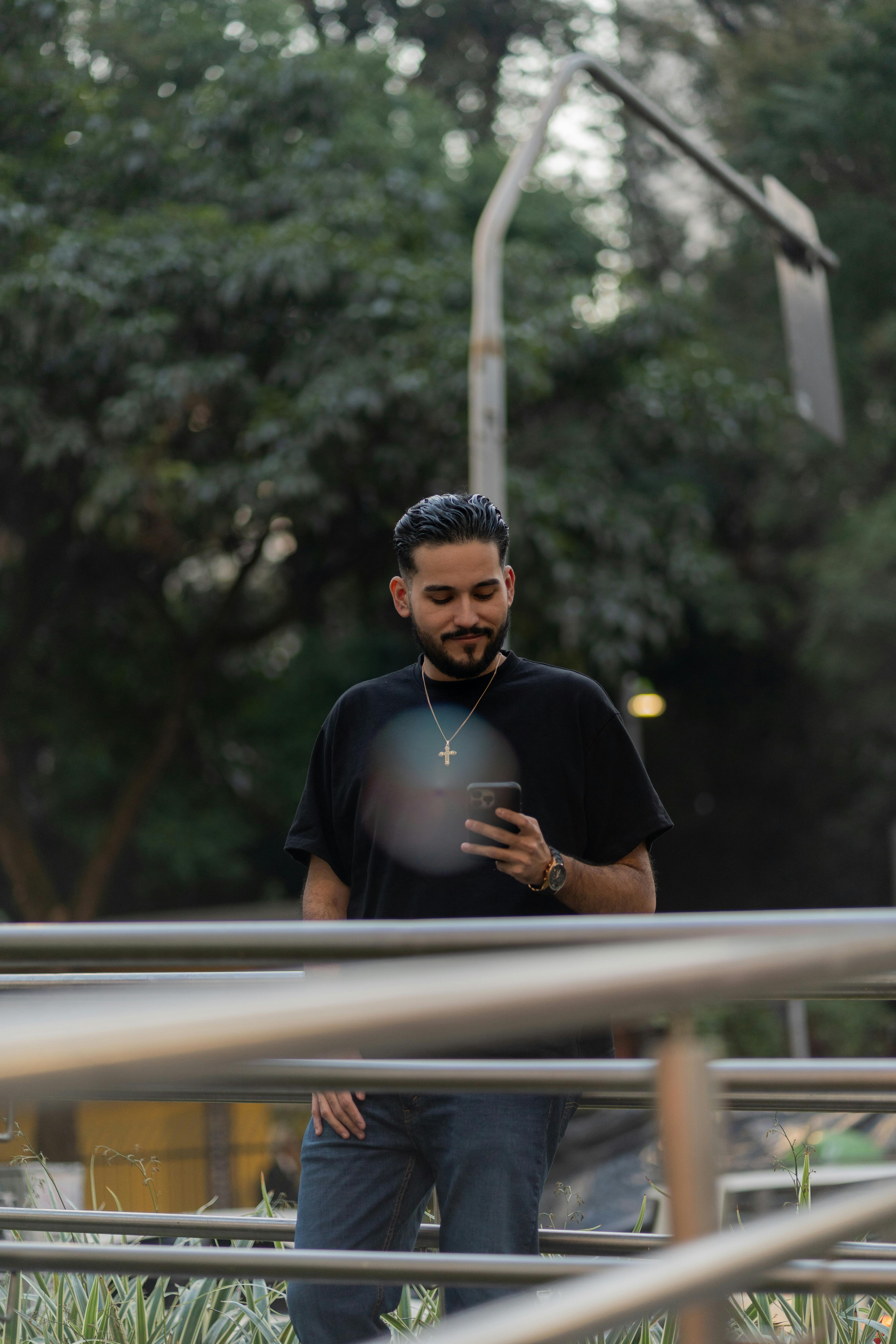 a man standing on a railing looking at his phone