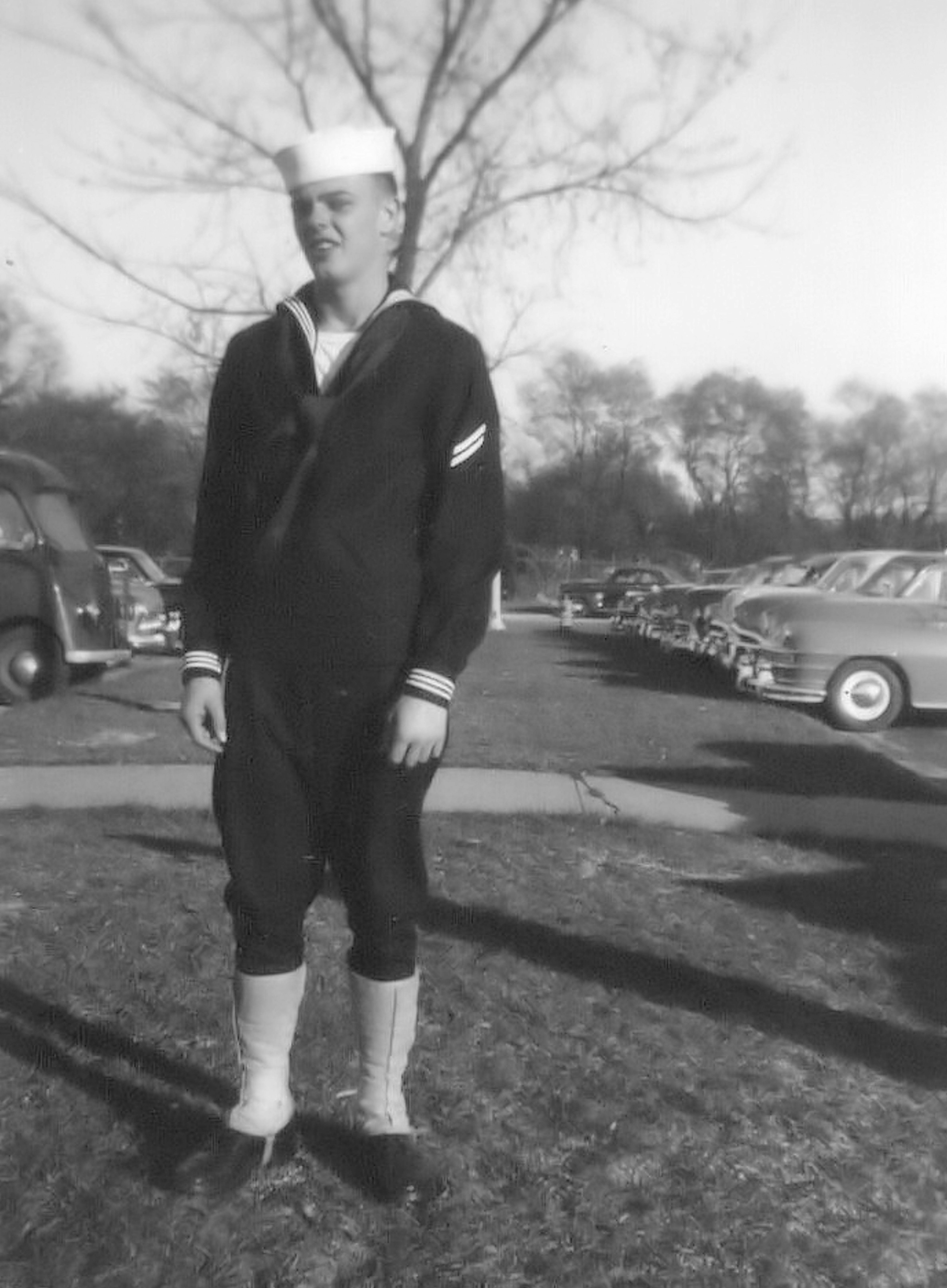 A young sailor in uniform stands outdoors in a vintage military portrait.