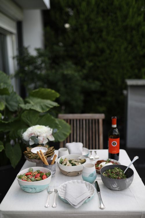 Free A charming outdoor dining table set with various dishes and a bottle of wine. Stock Photo