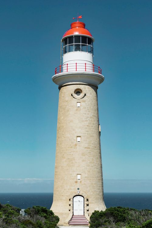 Free Scenic view of the historic Cape du Couedic Lighthouse against a clear blue sky in Flinders Chase, SA, Australia. Stock Photo
