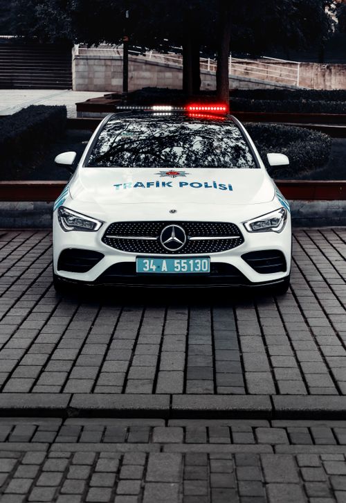 Free Turkish police car parked on a city street, displaying red and blue lights. Stock Photo