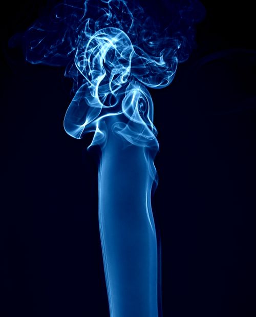Free Captivating blue smoke swirling on a dark background symbolizes mystique and creativity. Stock Photo