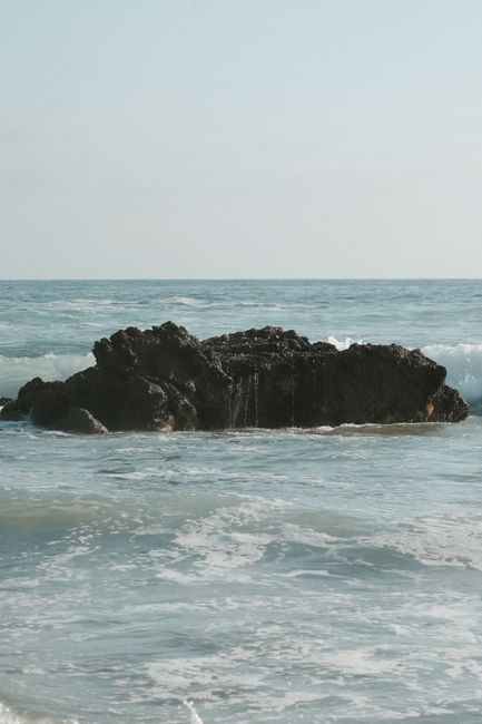 Tranquil view of a rocky shore with waves at Laguna Beach, California, perfect for summer scenes.