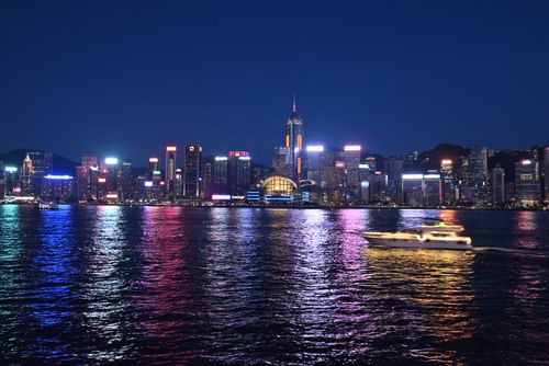 Free A stunning night view of Hong Kong's illuminated skyline reflecting on Victoria Harbour. Stock Photo
