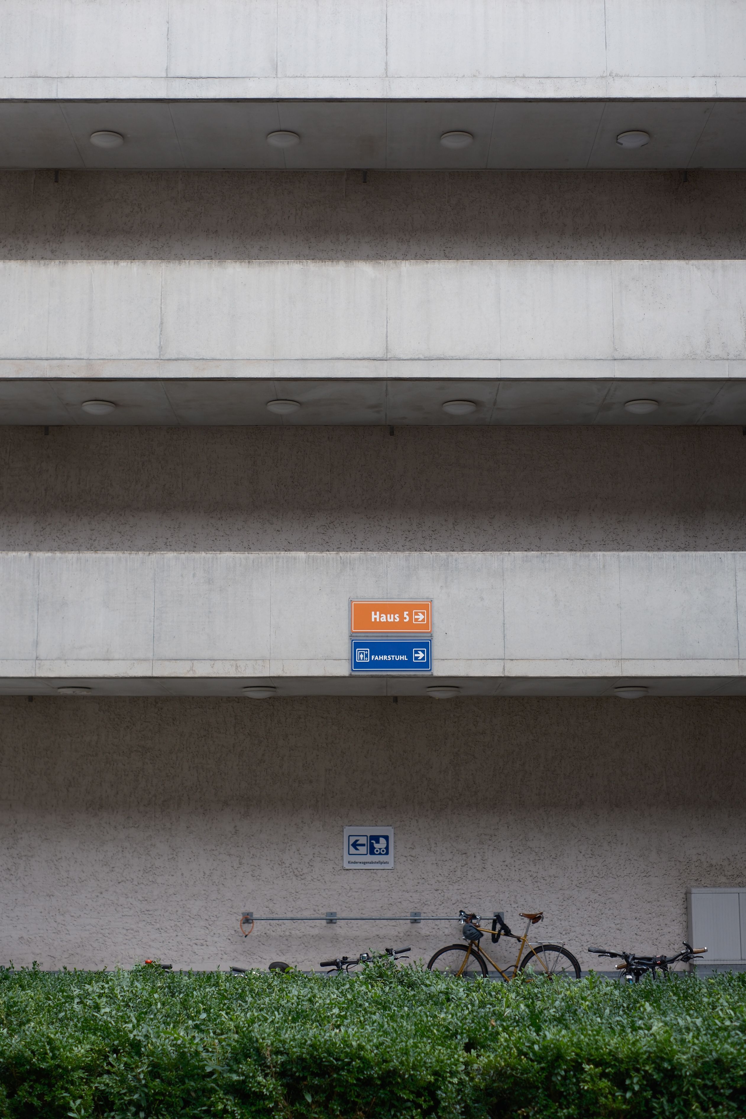 Concrete urban facade featuring bicycle parking and signage, perfect for city-related themes.