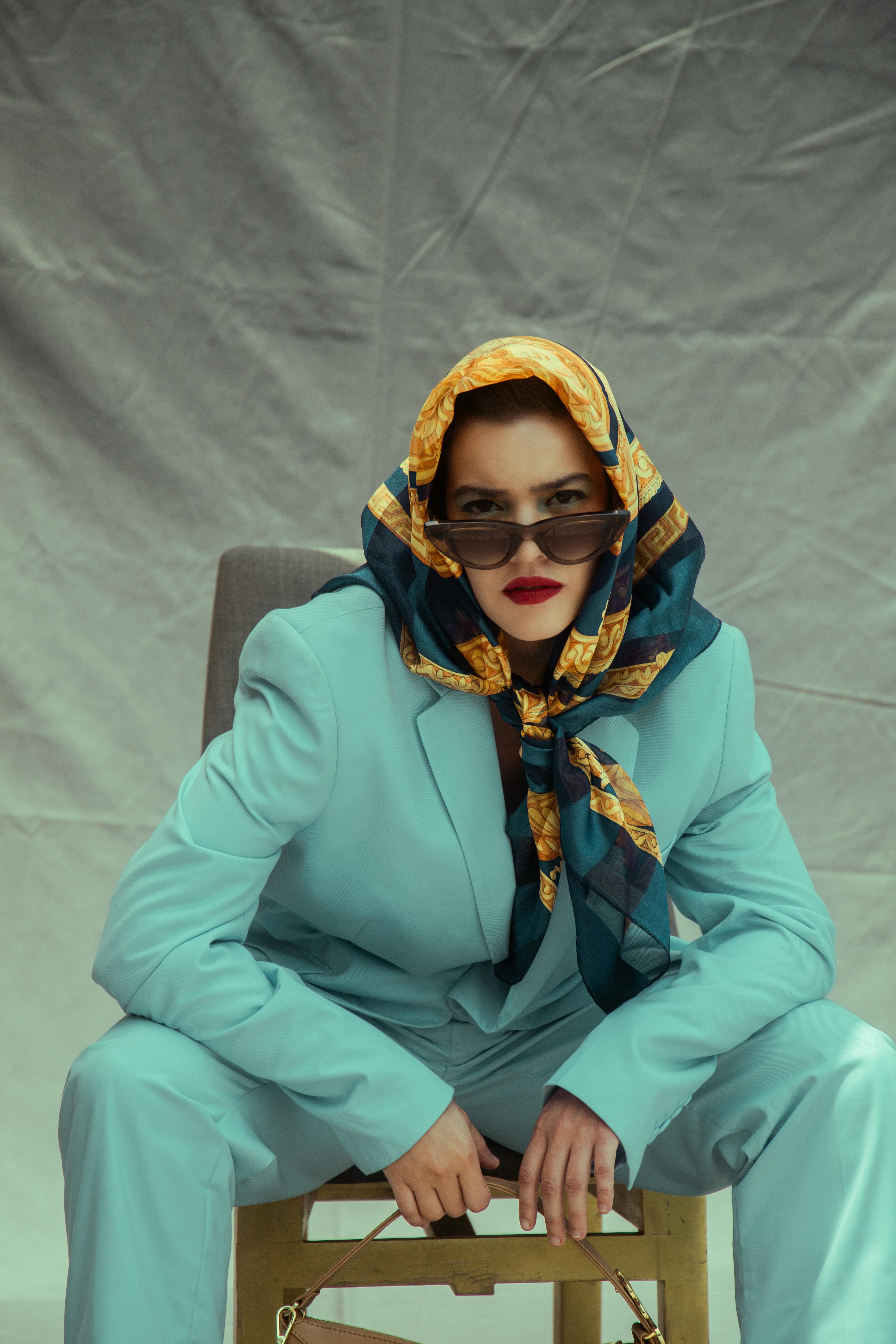 Free Fashionable woman in a colorful headscarf and stylish blue suit, exuding confidence and elegance. Stock Photo