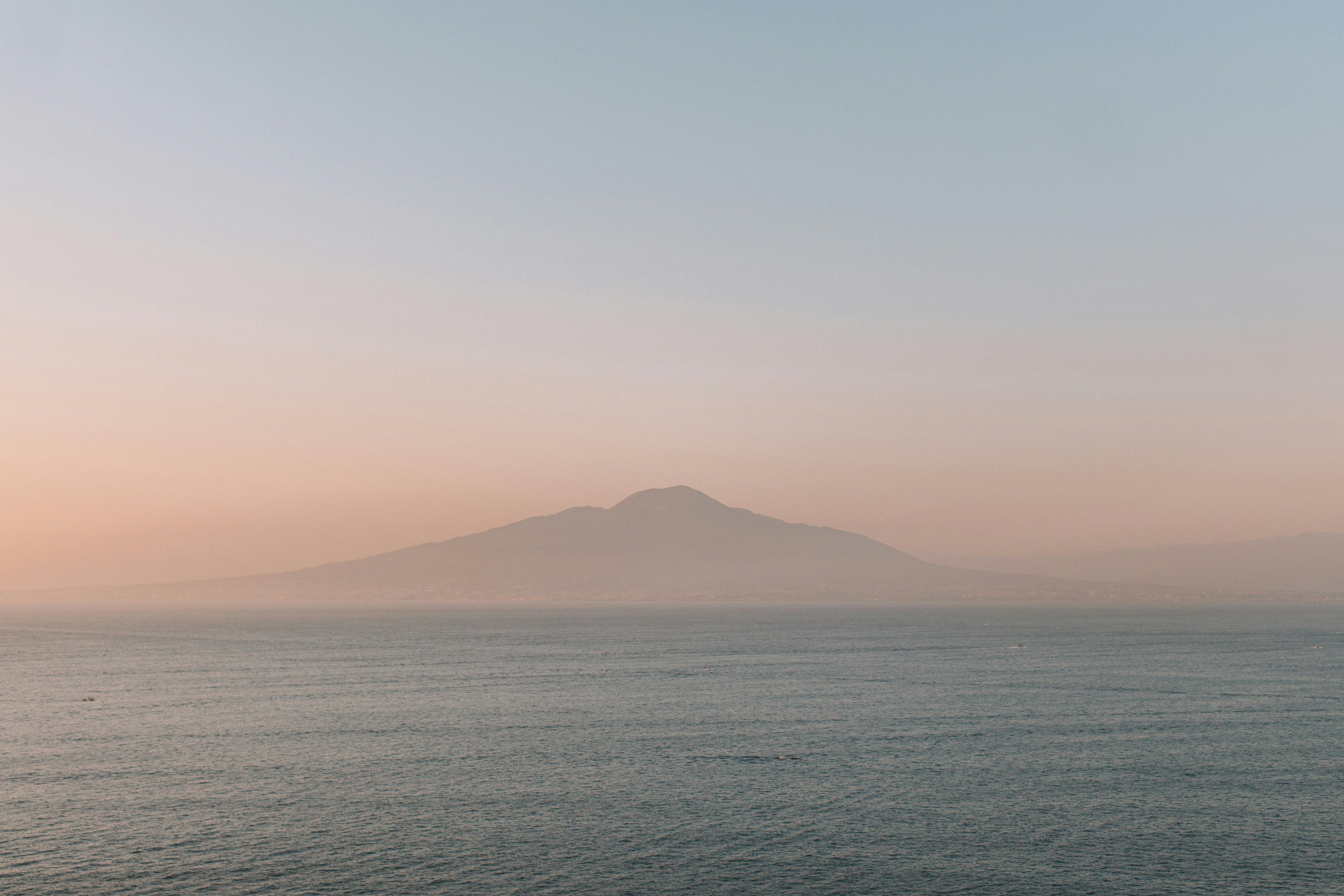 Admire the tranquil sunset over the Amalfi Coast, Italy, with misty mountainous backdrop.