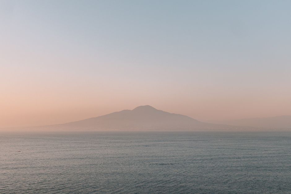 Admire the tranquil sunset over the Amalfi Coast, Italy, with misty mountainous backdrop.