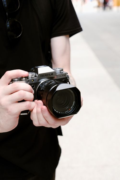 Free Close-up of a person holding a modern camera outdoors, showcasing photography and equipment. Stock Photo